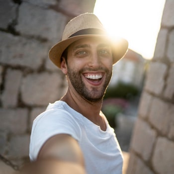 A man joyfully smiles while capturing a selfie